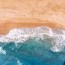 sea waves on brown sand drone view