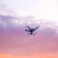 quadcopter drone flying under pink sky